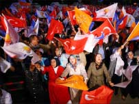 Supporters of Turkey 's ruling party the Justice and Development Party (AKP) celebrate with party flags after the first results of the parliamentary election in front of party headquarters in Ankara on June 12, 2011. /ADEM ALTAN/AFP/Getty Images 