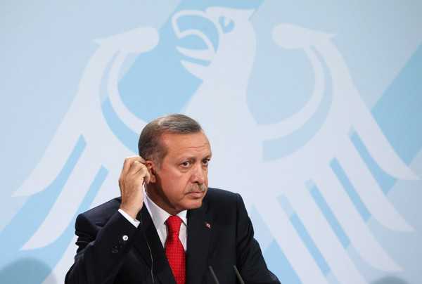 Adam Berry/Getty Images - Turkish Prime Minister Recep Tayyip Erdogan speaks during a news conference in Berlin. His plans to transform Turkey into a model of Muslim democracy face increased threats, both internal and external.